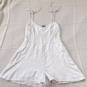 New, with tags sand colored romper. Size Medium